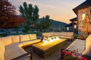 Fenced backyard with an outdoor living space with a fire pit, a mountain view, and a patio area
