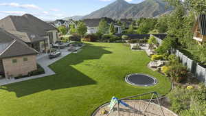 View of yard with a patio, a residential view, a trampoline, and a mountain view