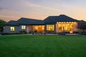 Back of property with a patio area, an outdoor living space, and a lawn