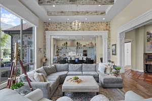 Tiled living room with a towering ceiling, recessed lighting, and a chandelier