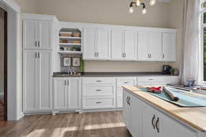 Kitchen featuring open shelves, a sink, white cabinetry, and light wood-style floors