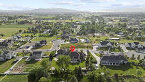 Aerial view of property and surrounding area with mountains and nearby suburban area