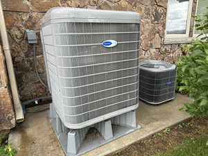 Exterior view of central air condition unit and stone siding