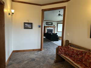 Corridor with baseboards and crown molding