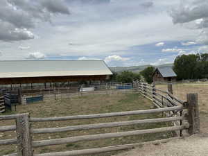 View of yard featuring a rural view, an exterior structure, an outdoor structure, and a mountain view
