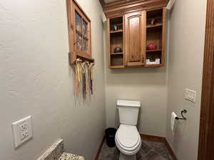 Bathroom featuring toilet and baseboards