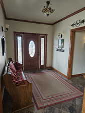 Entrance foyer with baseboards and crown molding