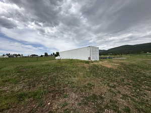 View of yard with a mountain view, a view of rural / pastoral area, and an outbuilding