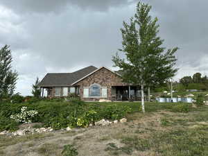 Single story home with stone siding and roof with shingles