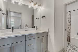 Bathroom featuring double vanity and shower / bath combo with shower curtain