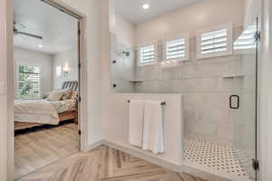 Ensuite bathroom with a tile shower, a ceiling fan, and recessed lighting
