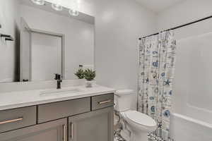 Full bath with vanity, shower / bath combo with shower curtain, and tile floors