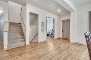 Entrance foyer with light wood-style floors, recessed lighting, and stairway