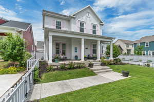 View of front of house featuring covered porch, french doors, and a fenced backyard