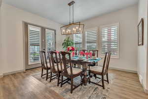 Dining room with plenty of natural light, light wood finished floors, and a chandelier