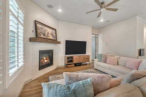 Family room featuring a ceiling fan, light wood finished floors, a fireplace, and recessed lighting