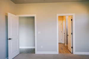 Unfurnished bedroom with wood finished floors and baseboards