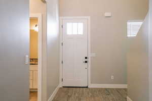 Foyer entrance with light wood-type flooring and baseboards