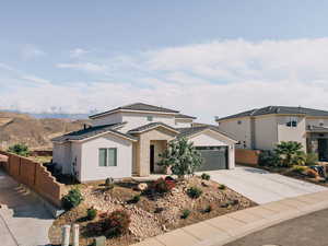 Traditional-style house with driveway, a garage, and stucco siding