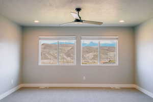 Unfurnished room with light carpet, healthy amount of natural light, a ceiling fan, and recessed lighting