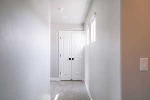 Corridor featuring carpet flooring and baseboards