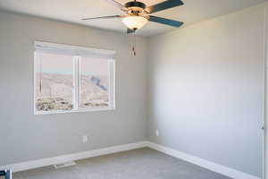 Unfurnished room featuring ceiling fan, baseboards, and carpet floors