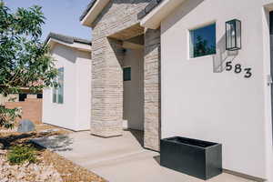 Doorway to property with stone siding and stucco siding