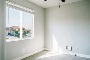 Unfurnished room with a ceiling fan, carpet, and baseboards