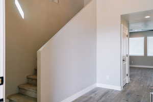 Stairway featuring wood finished floors, baseboards, and recessed lighting