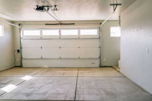 Garage with a garage door opener and baseboards