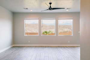 Unfurnished room featuring healthy amount of natural light, ceiling fan, wood finished floors, baseboards, and recessed lighting