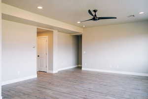 Empty room featuring ceiling fan, light wood-style floors, baseboards, and recessed lighting