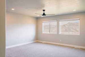 Spare room featuring a ceiling fan, light carpet, recessed lighting, baseboards, and a textured ceiling