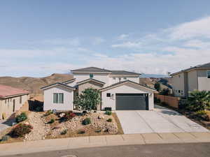 Traditional-style home with a garage, driveway, stucco siding, and a mountain view