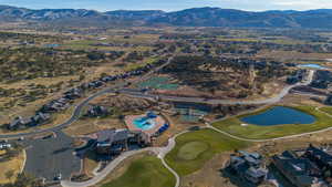 Aerial view of property's location with a water and mountain view and a golf club