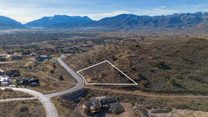 Aerial view of property's location with a mountain backdrop and property parcel outlined