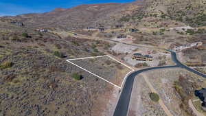 Aerial view of property's location with property boundaries highlighted and a mountainous background