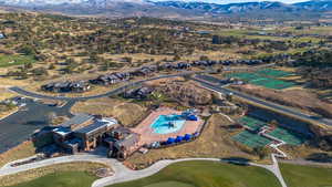 Aerial view of residential area featuring a mountain backdrop and a golf course