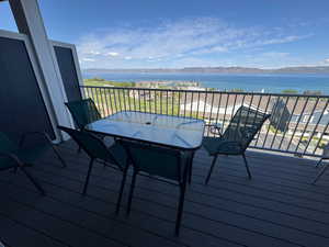 Wooden deck with a water and mountain view and outdoor dining area