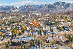 Aerial view of property and surrounding area with mountains and nearby suburban area