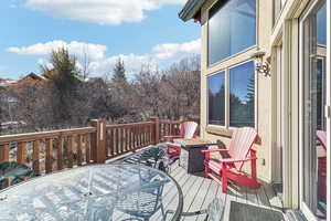 Wooden terrace with outdoor dining space and a fire pit