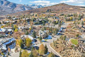 Aerial view of property and surrounding area featuring mountains and nearby suburban area