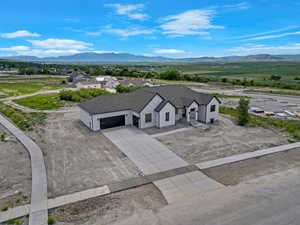 Aerial view of property and surrounding area featuring a mountain backdrop