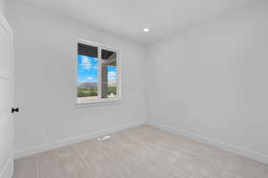 Spare room featuring carpet, baseboards, and recessed lighting