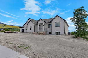 View of front of home with central AC, stucco siding, and a mountain view