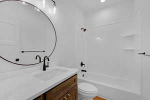 Full bathroom featuring vanity, toilet, and tub / shower combination