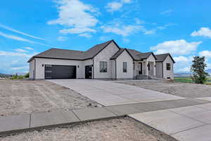View of front of home featuring a garage, driveway, and stucco siding