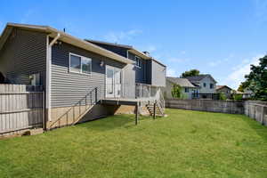 Rear view of house with a fenced backyard, a chimney, and a residential view