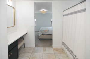 Bathroom featuring vanity, ensuite bathroom, baseboards, and a shower with shower curtain