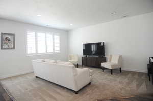 Living room featuring baseboards, recessed lighting, and carpet floors